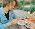 A man enjoying a healthy meal with fresh vegetables at an outdoor picnic table.