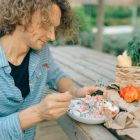 A man enjoying a healthy meal with fresh vegetables at an outdoor picnic table.